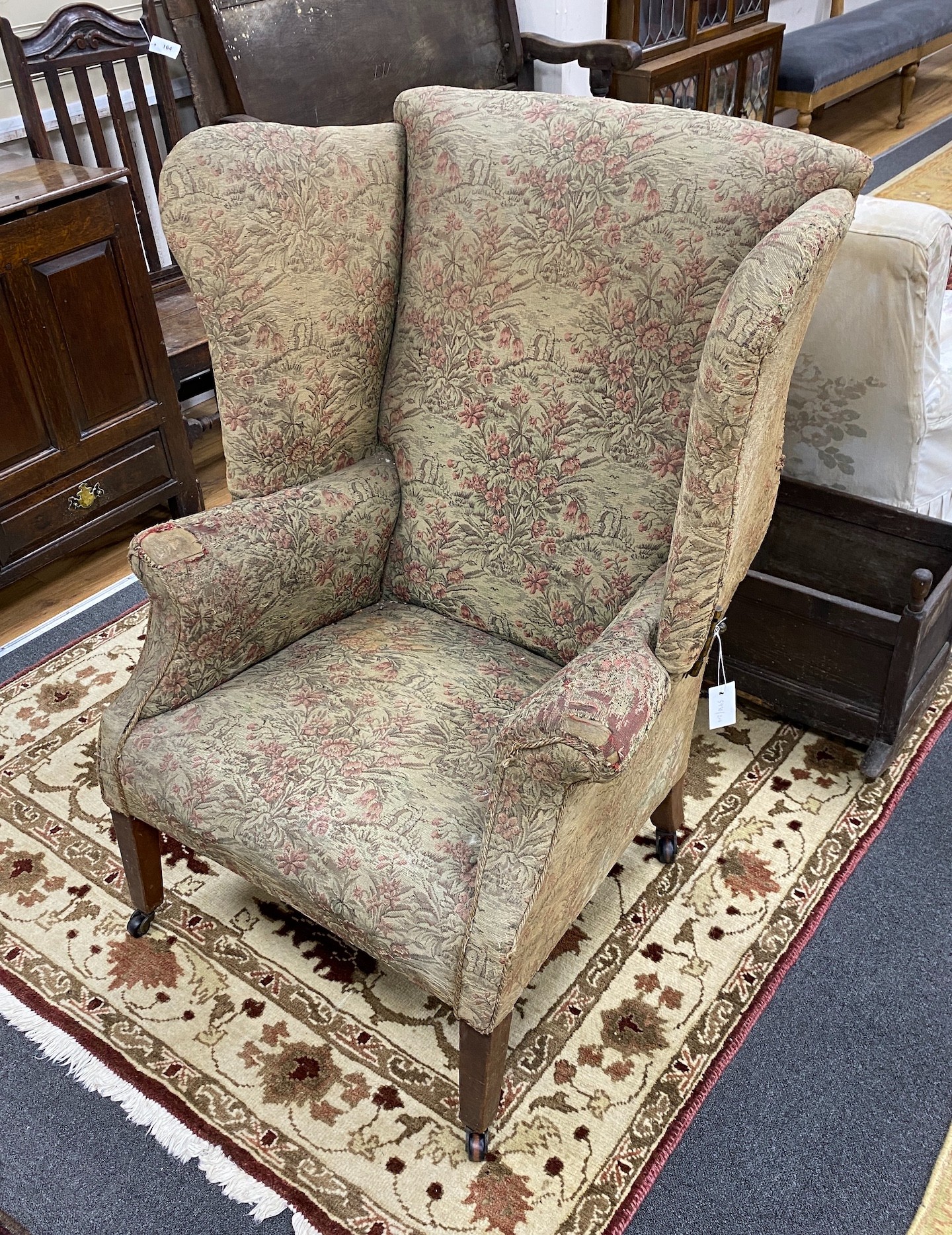 A George III mahogany wing armchair with folding sides, width 86cm, depth 66cm, height 107cm